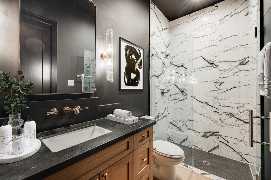 Virtually staged bathroom with dark vanity and brass hardware