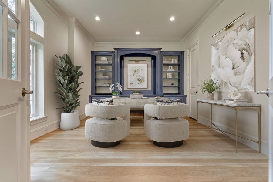 Digitally staged home office with navy built-ins and white desk chair in texas