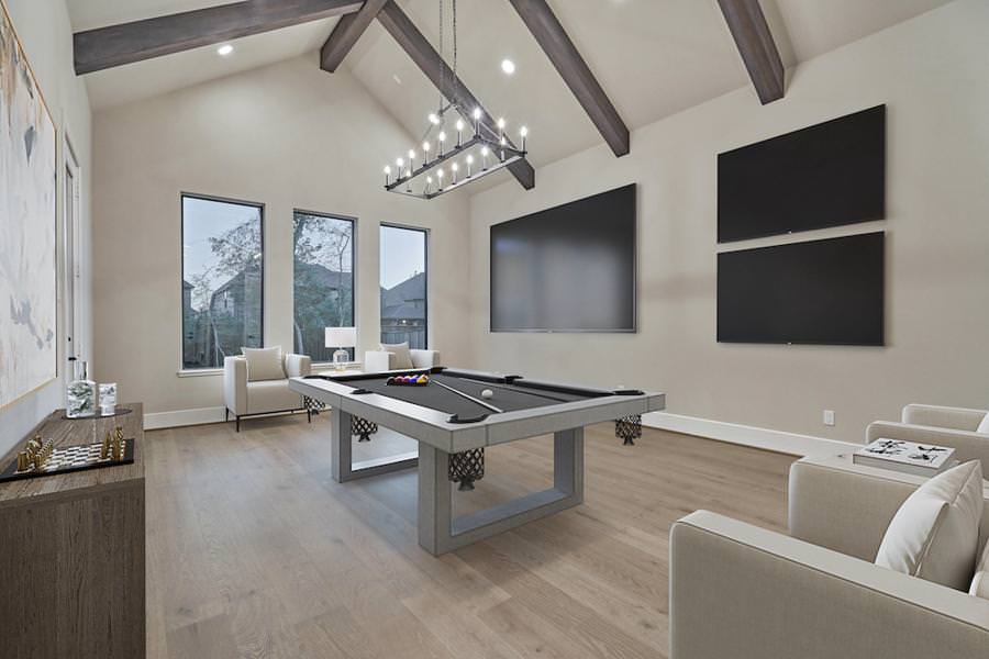 Modern game room with vaulted ceiling, pool table, and triple wall-mounted TVs.