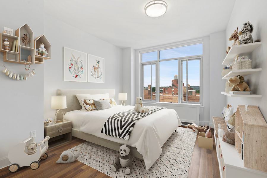 Gender-neutral nursery with city view, white bedding, and woodland-themed artwork