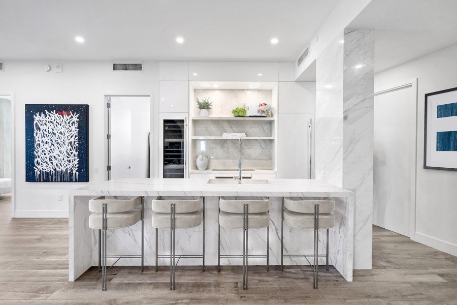 Virtual home staging of a marble kitchen island with modern bar stools in a Florida home