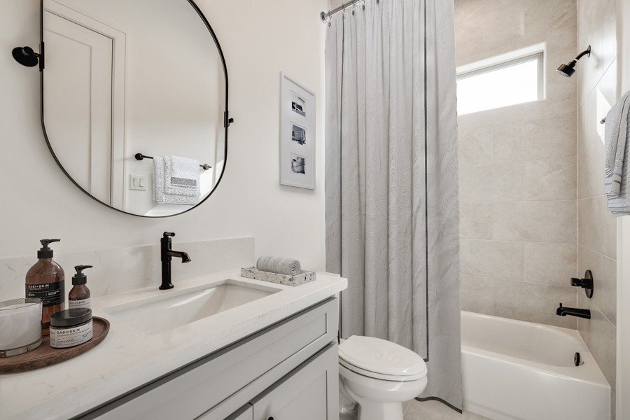 Virtually staged minimalist bathroom with gray vanity and matte black accents
