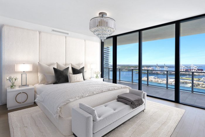 Modern bedroom digitally staged with sleek white furnishings and city view.