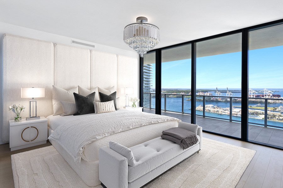Modern bedroom digitally staged with sleek white furnishings and city view.
