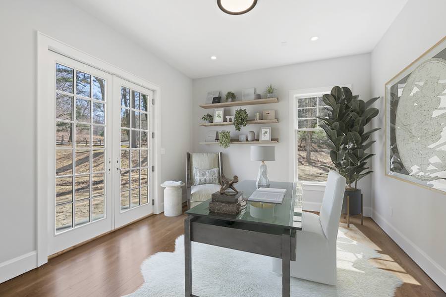 Bright home office with glass desk, floating shelves, and modern decor virtually staged for a clean, professional look in california