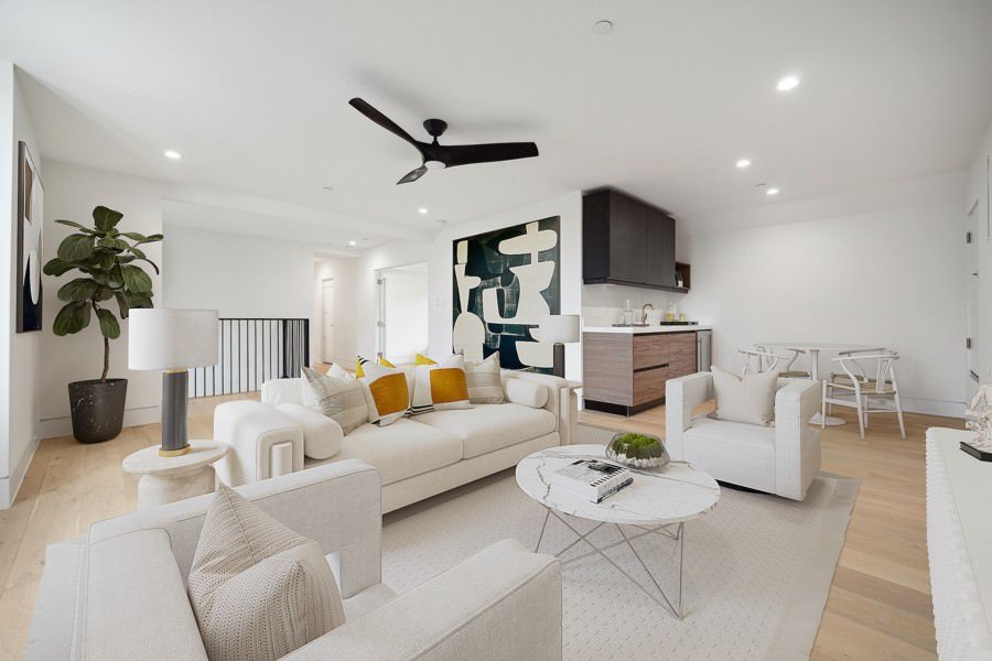 Modern white living and dining room with sleek neutral furniture, bold geometric wall art, a built-in bar, and warm wood flooring.