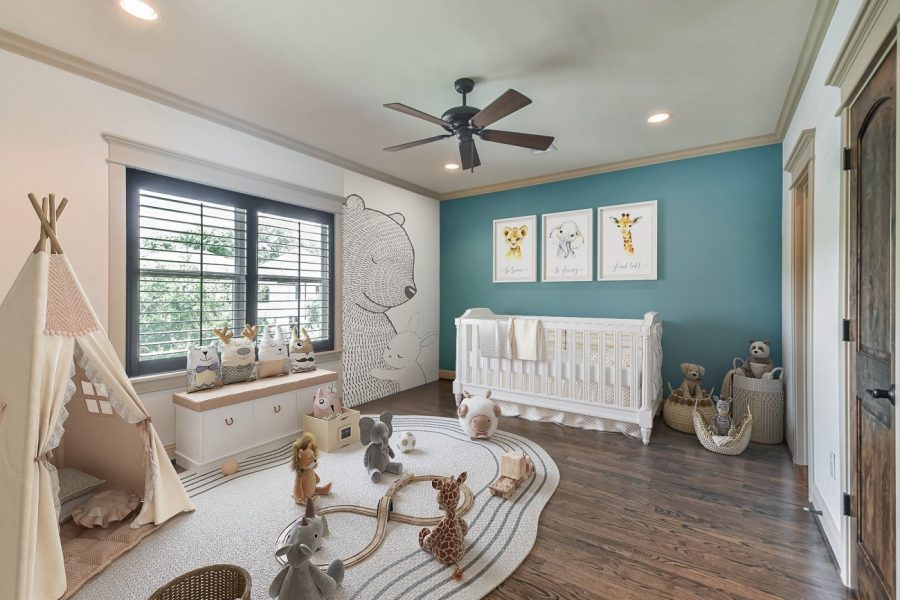 Digitally staged nursery with blue accent wall, animal artwork, and playful decor elements in texas