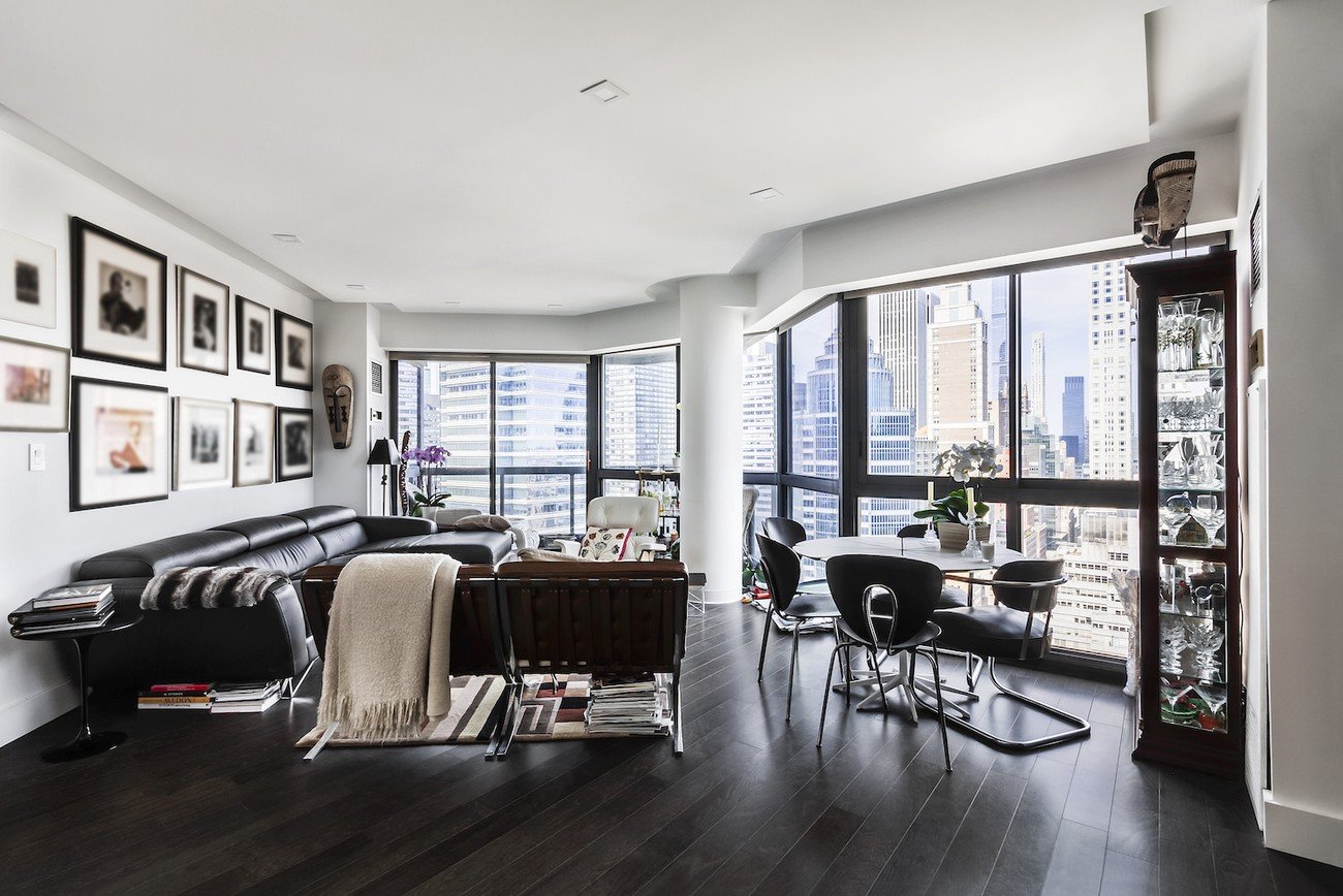 Empty modern high-rise room with floor-to-ceiling windows and skyline views, prepped for virtual staging