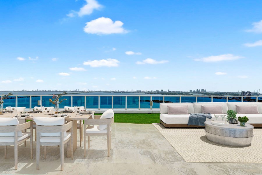 Ocean-facing patio virtually staged with lounge chairs and dining table