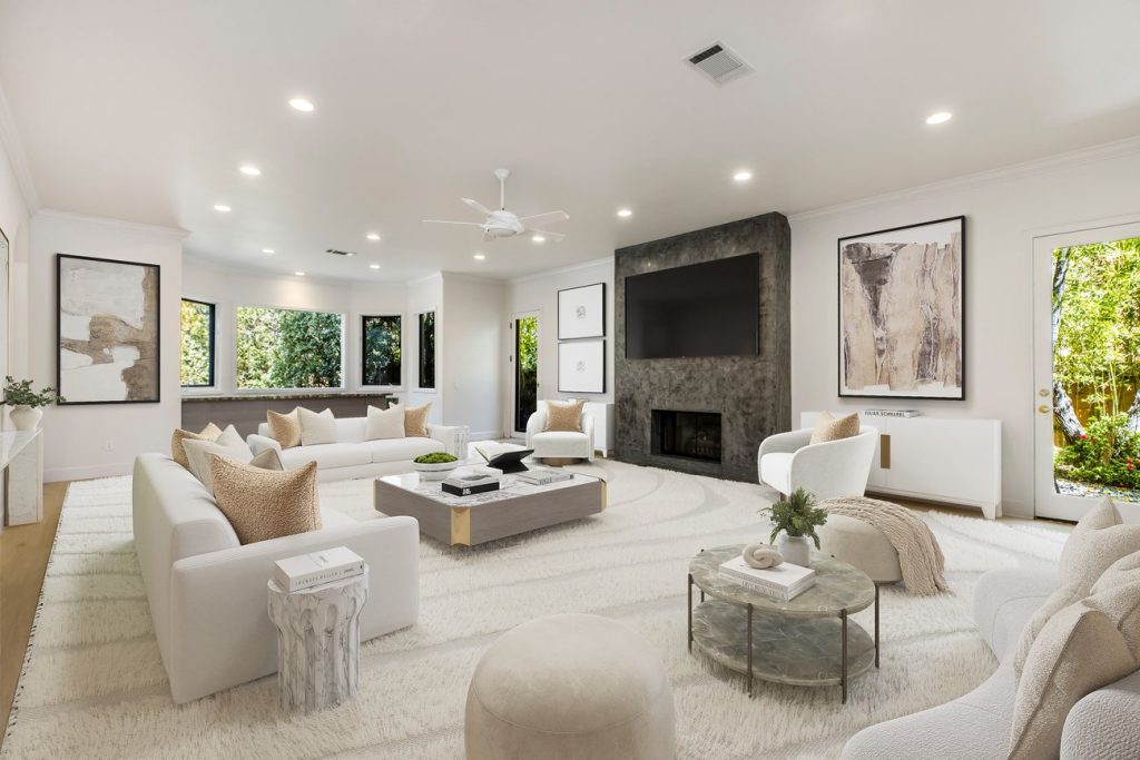 Virtual staging of an open-concept great room with white furniture, textured area rug, modern coffee tables, and concrete fireplace in texas