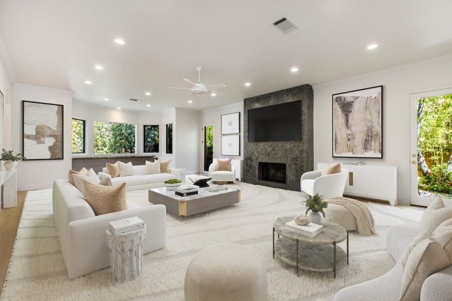Virtual staging of an open-concept great room with white furniture, textured area rug, modern coffee tables, and concrete fireplace in texas