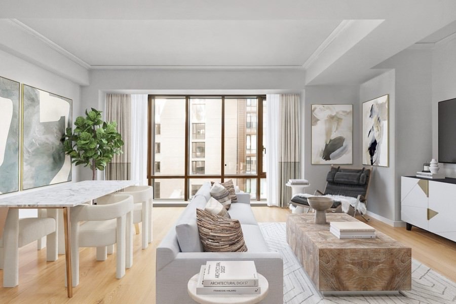 Open-concept living and dining area with soft neutral tones, abstract artwork, and floor-to-ceiling windows bringing in natural light.