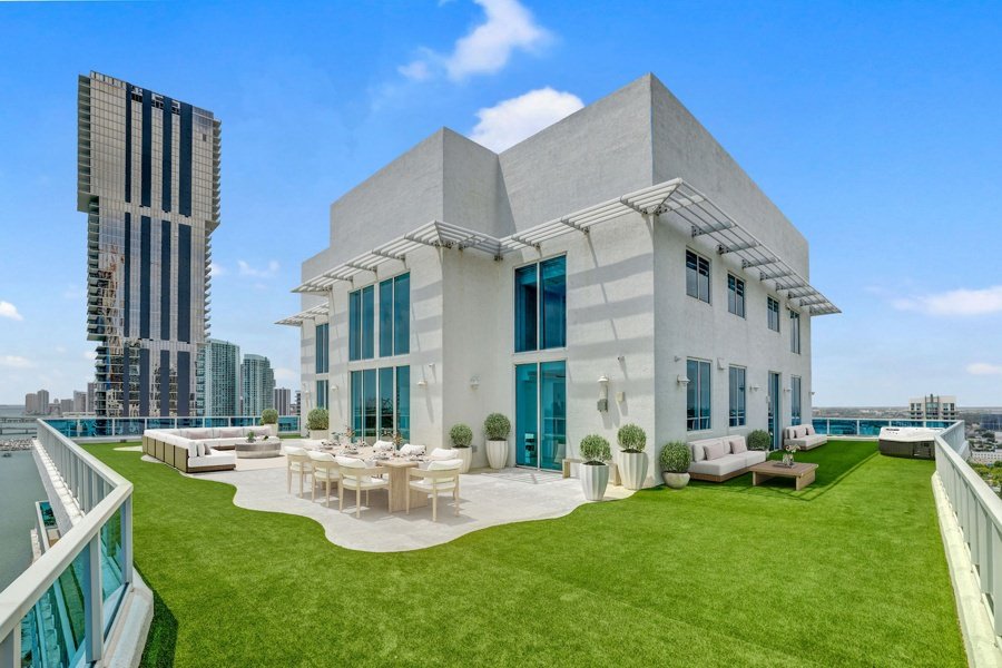 Penthouse rooftop terrace virtually staged with lawn, planters, and dining set