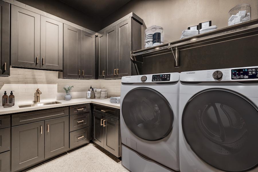 virtually staged Moody laundry room with dark cabinetry, white counters, and Samsung washer-dryer.