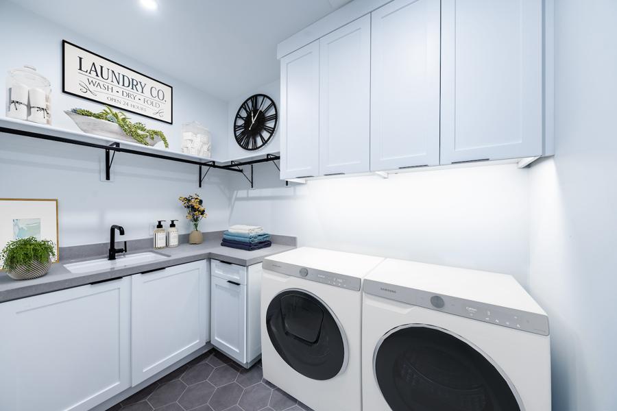 virtual staging Fresh and modern laundry room with soft blue cabinetry, black fixtures, and styled shelving