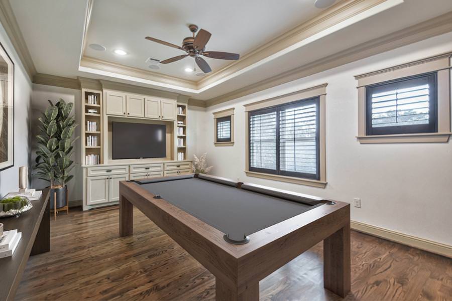 Traditional game room with wood trim, built-in entertainment center, and pool table.