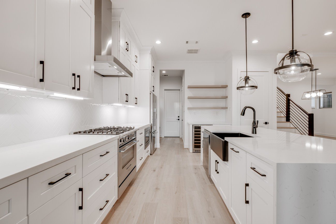 Bright all-white kitchen with pendant lighting and shaker cabinets prior to virtual staging.