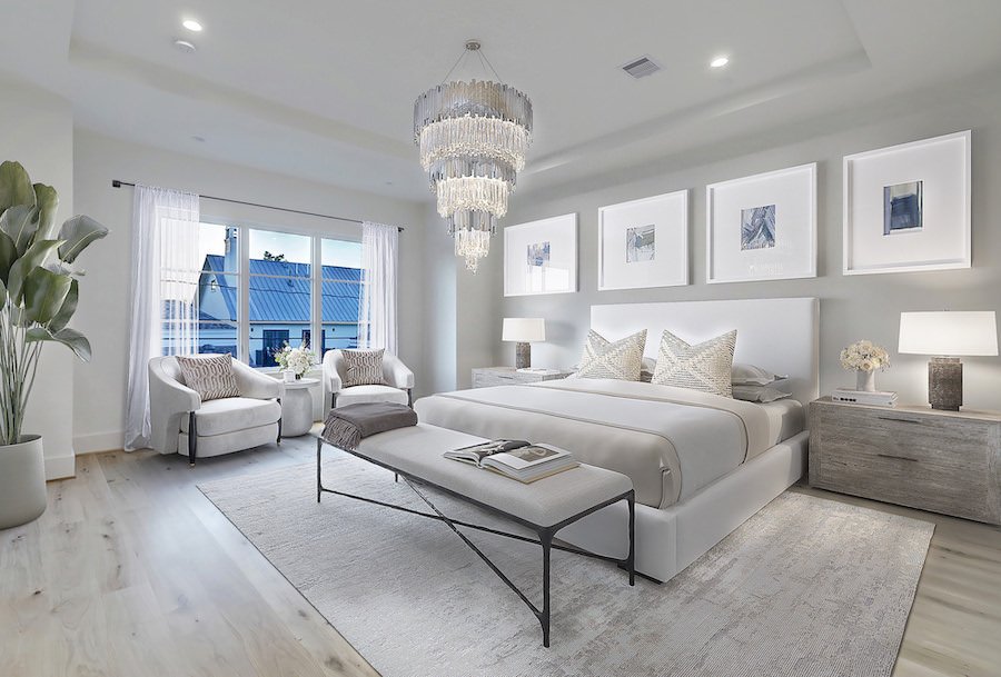 Staged bedroom with chandelier and soft textures in texas